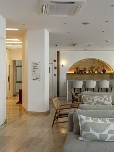 Lobby bar niche lit in warm gold behind white bar stools