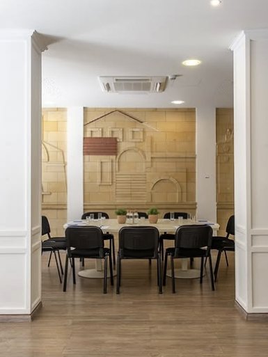 Boardroom table beneath a carved limestone relief of old Nicosia
